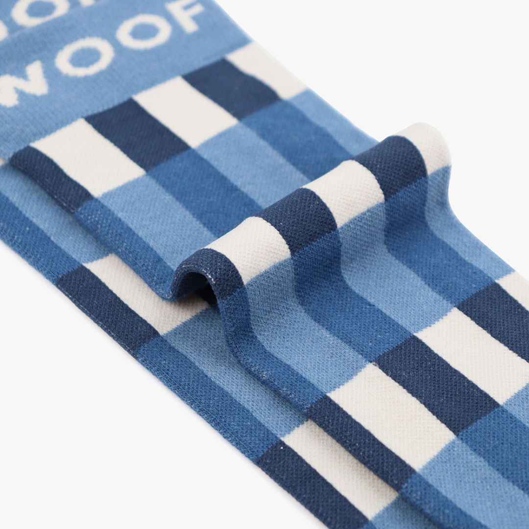 Folded view of blue and white gingham plaid knee-high compression socks displaying top cuff branding.